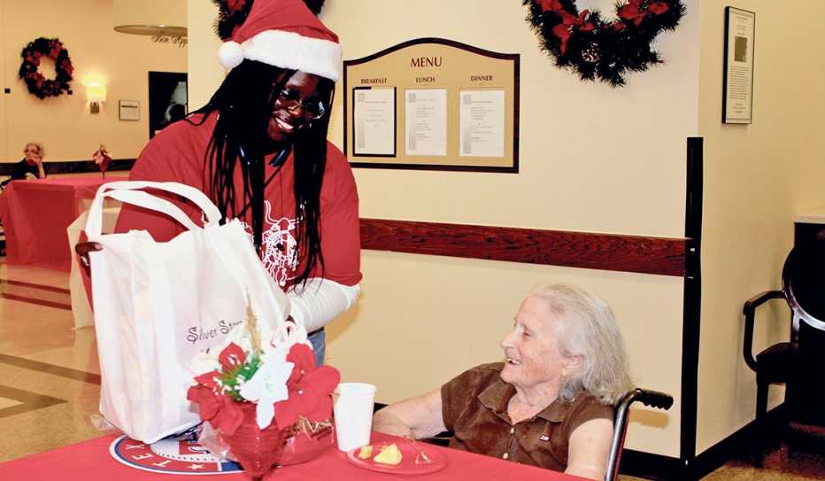 A Silver Stars volunteer delivers holiday gifts to a woman in a nursing home A Silver Stars volunteer delivers holiday gifts to a woman in a nursing home