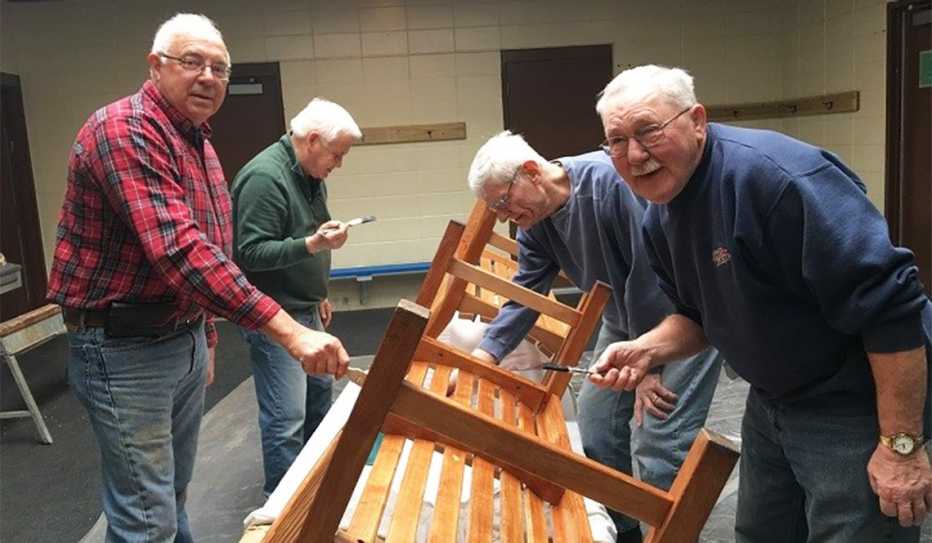 Four men building and staining benches