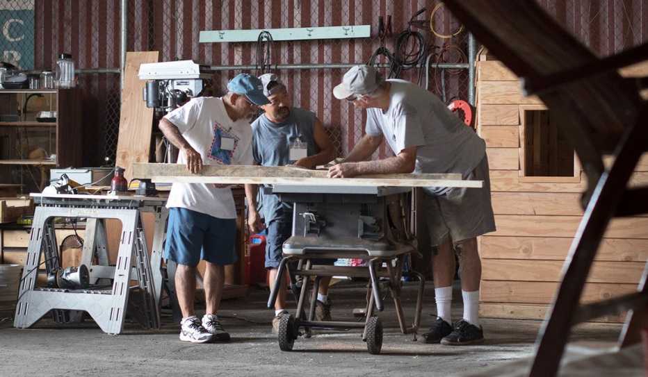 Three men working in a men's shed