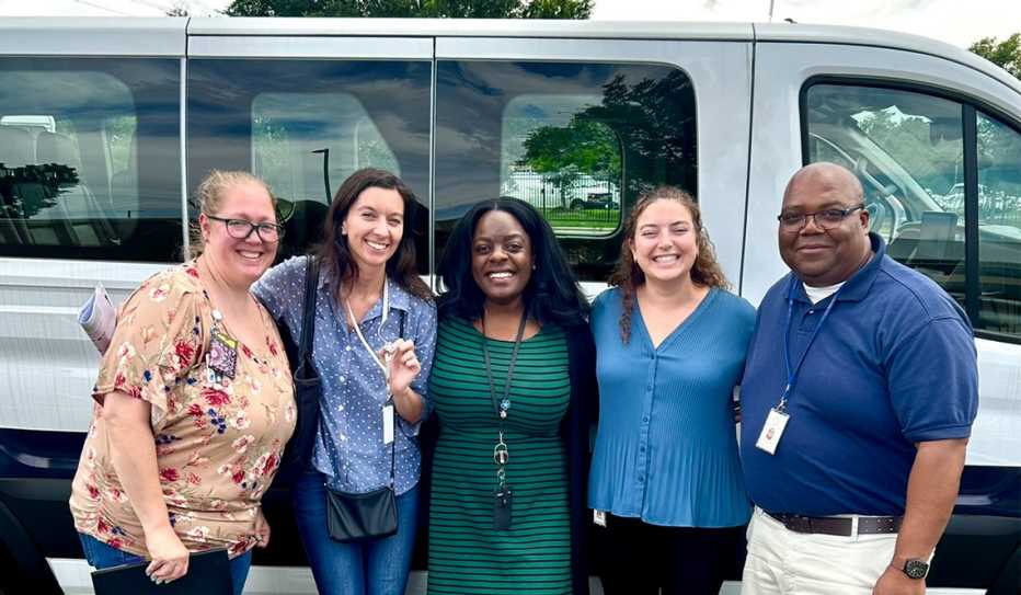 Representatives from Mecklenberg, North Carolina's on-call transportation service stand in front of a shuttle bus Representatives from Mecklenberg, North Carolina's on-call transportation service stand in front of a shuttle bus