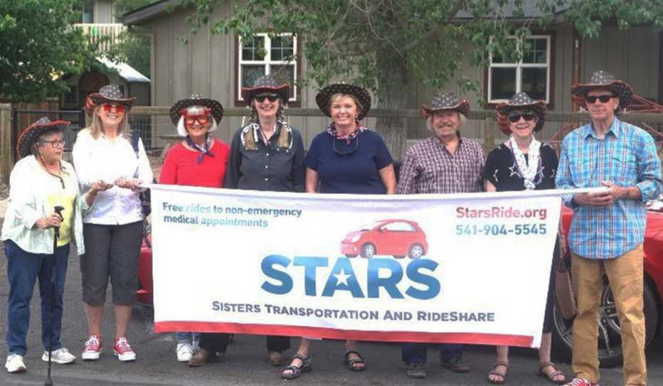 Volunteers with the STARS transportation service display a parade banner Volunteers with the STARS transportation service display a parade banner
