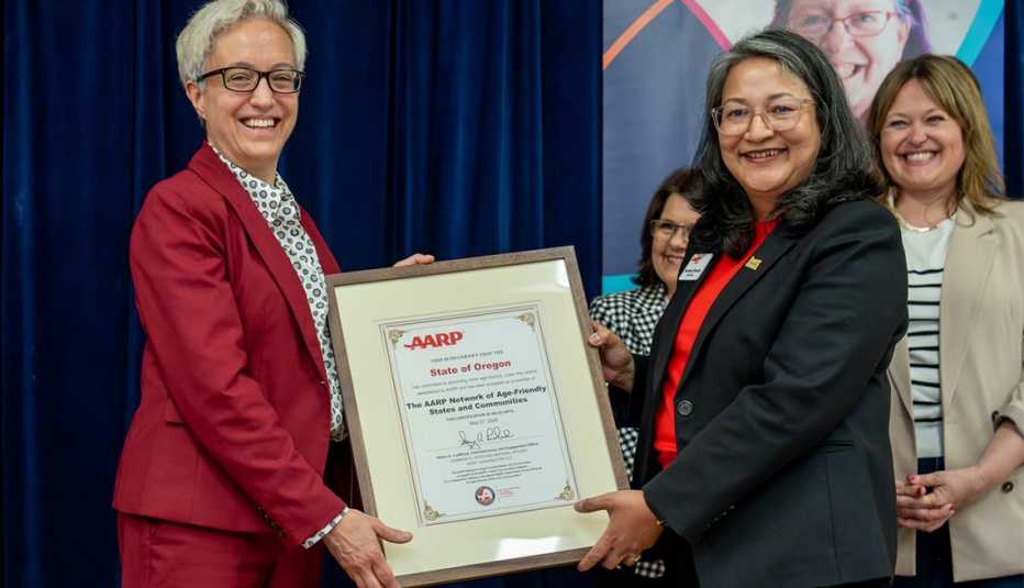 Oregon Governor Tina Kotek accepts a certificate from AARP Oregon State Director Bandana Shrestha to commemorate the state’s enrollment in the AARP Network of Age-Friendly States and Communities. 