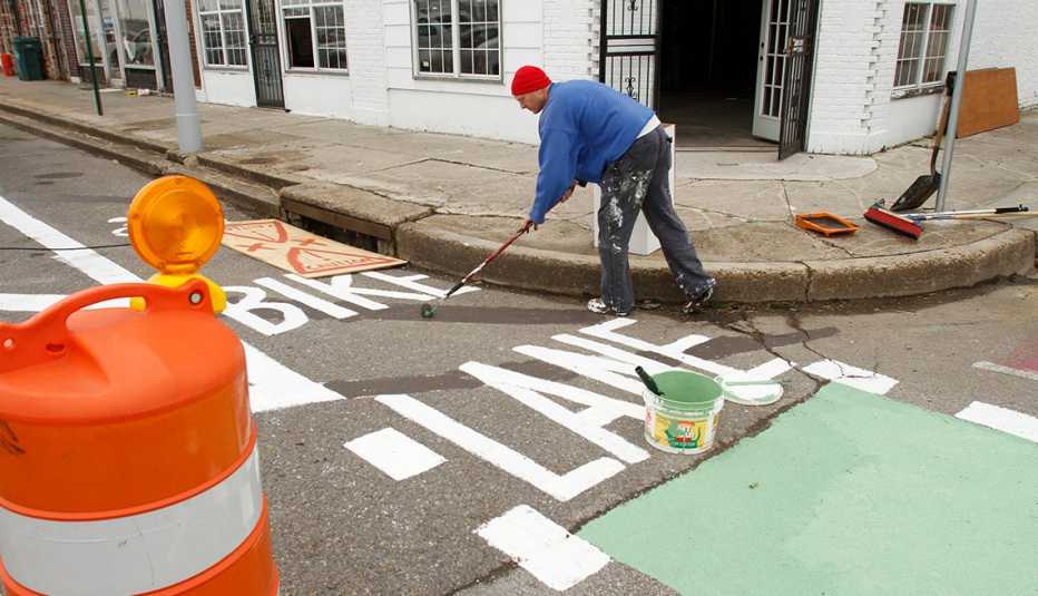 Man Paints Street And Bike Lane, Revitalization Project, Livable Communities Local artist and event volunteer Tom Clifton helped paint the event's pop-up bicycle lane.
