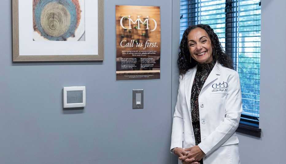 docter christine meyer poses in her office next to a poster explaining her bat phone sytsem