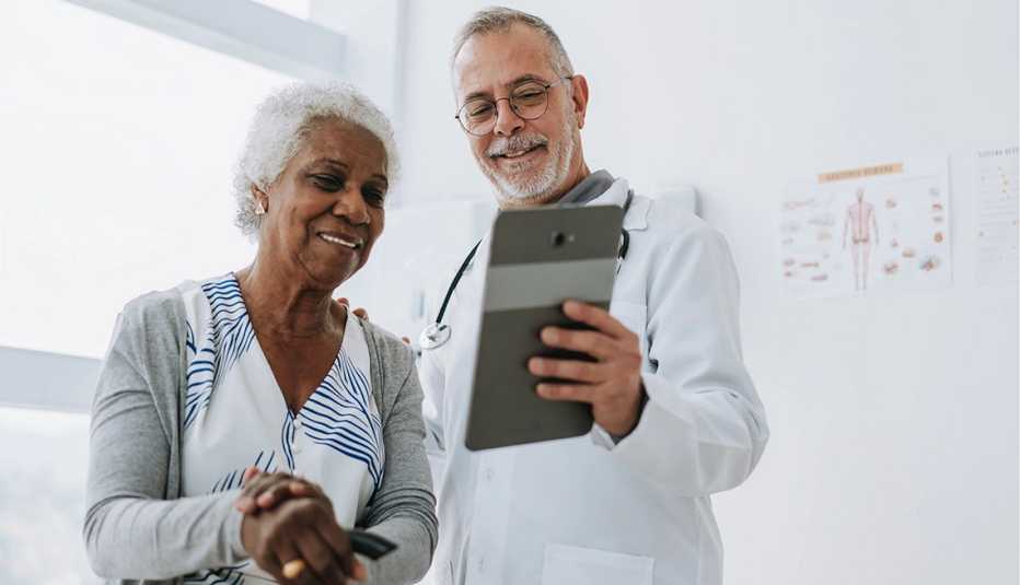 a doctor showing a tablet to a patient in a hospital room