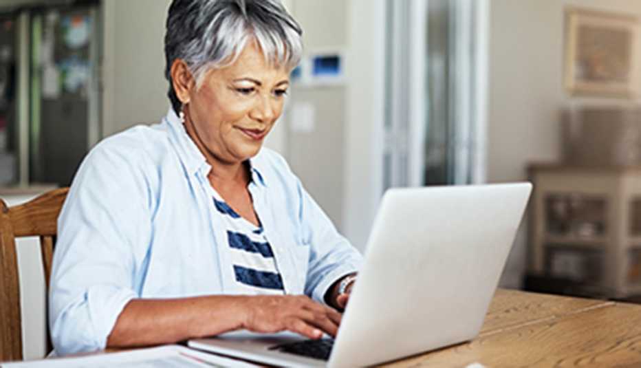 a woman sitting at a table on her laptop