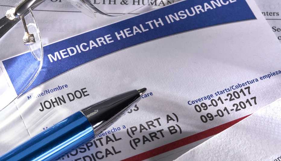 Medicare card, glasses, and pen on a desk