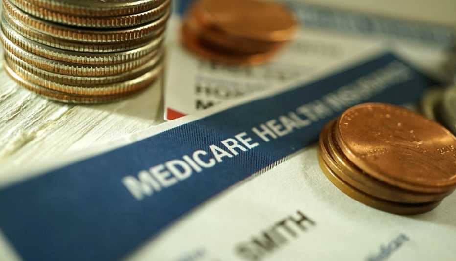 close up of a medicare card with stacks of pennies and quarters on top of it