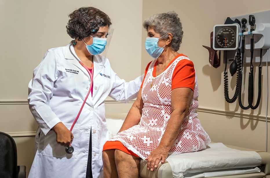 doctor annie syed with a  patient in an exam room