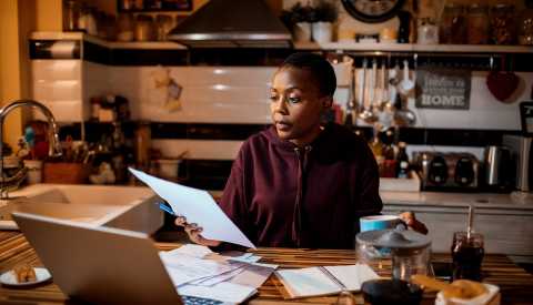 Woman  at desk with laptop & coffee Woman  at desk with laptop & coffee