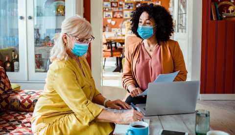 2 women sitting coffee table 2 women sitting coffee table