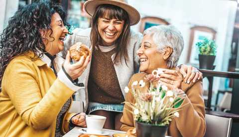 Mature group of ladies enjoying coffee and pastries together at a local restaurant