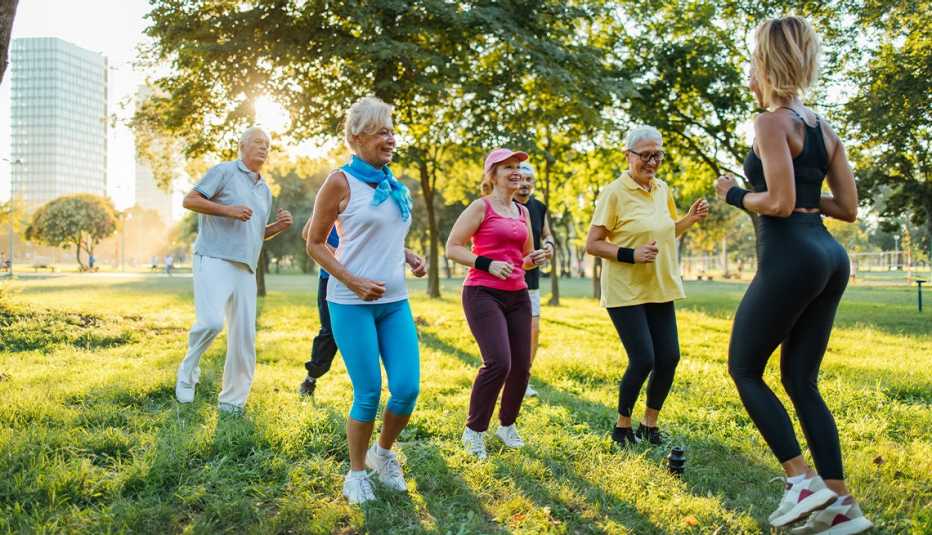 Group of mature adults taking a fitness class together outdoors 