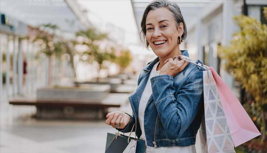 Woman wearing a jean jacket carrying shopping bags