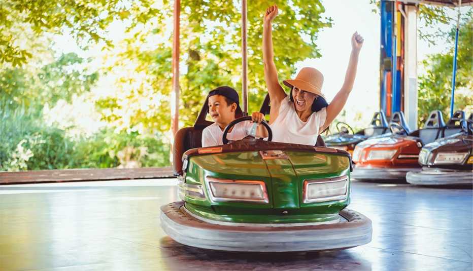 Woman and son riding in a green bumper car at a theme park