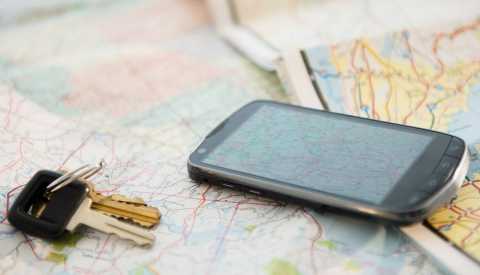 car keys and cell phone laying on a paper road map