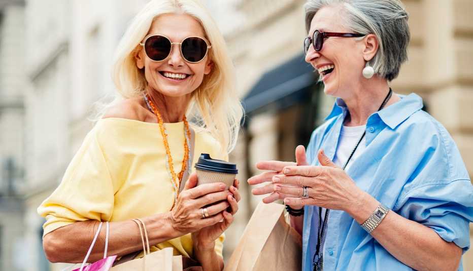 AARP members holding shopping bags and coffee cups as they stroll through a local street