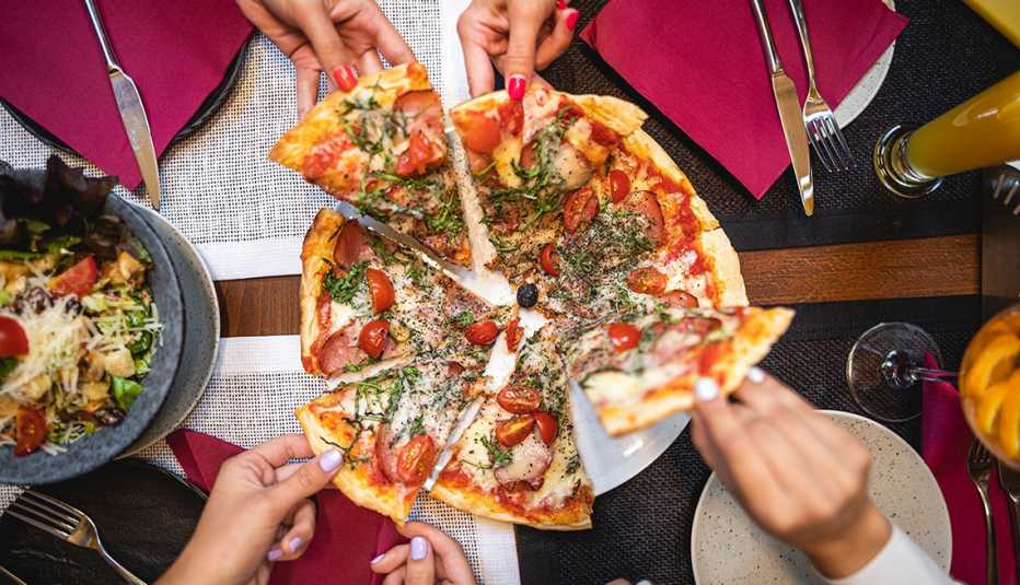 patrons grabbing pizza slices and enjoying their member discount on dining