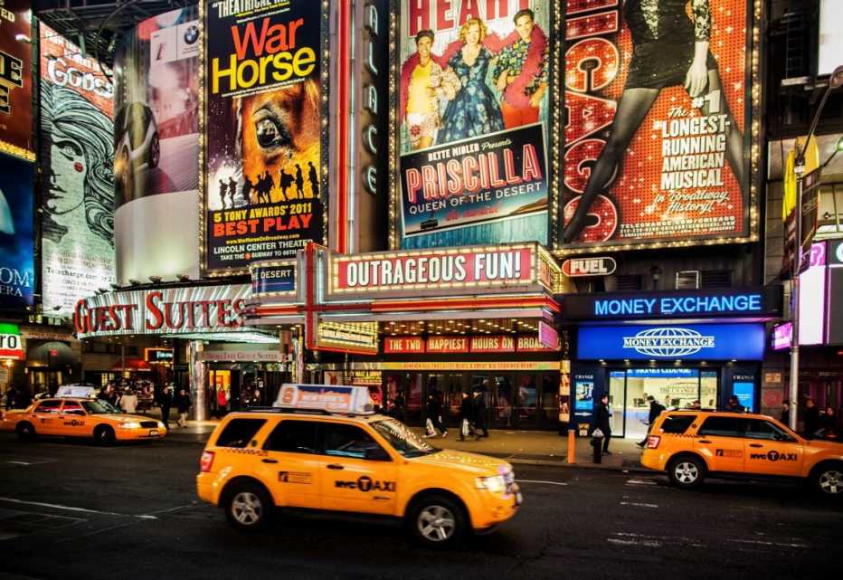 photo of broadway at night with marquees lit up
