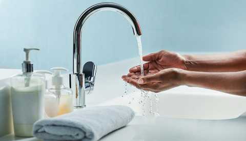 man washing his hands in a bathroom sink