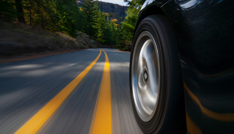 bottom of car, showing one wheel on road near middle yellow lines