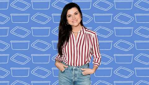 tiffani thiessen wearing jeans and white and red striped shirt; hands in pockets; blue background with illustrations of dishes on it