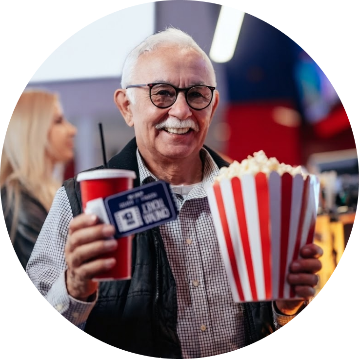 man holding movie popcorn, soda, and tickets showing what you could win.