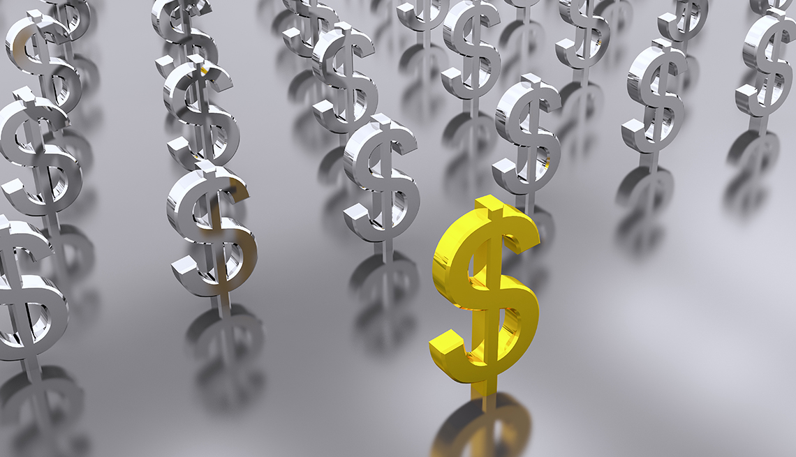 Un signo de dólar dorado al frente de varios signos plateados.