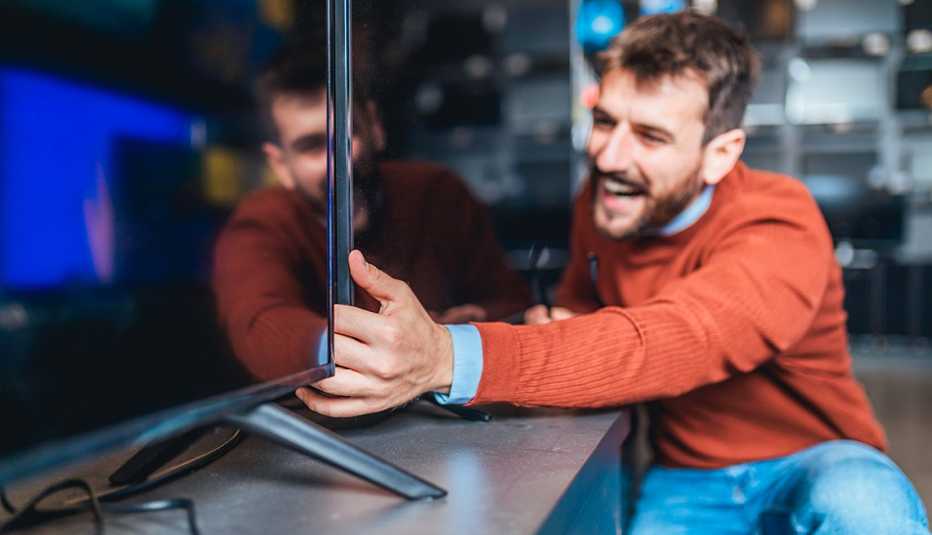 man looking at television sets in store