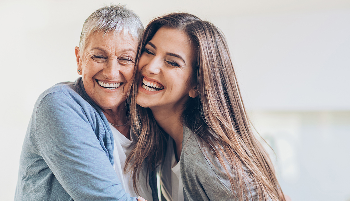Senior mother and younger daughter embracing at home
