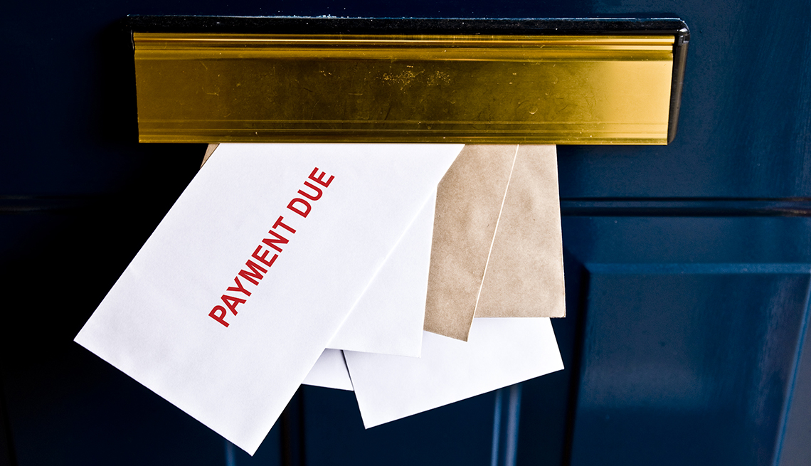Letters in front door mail slot saying payment due