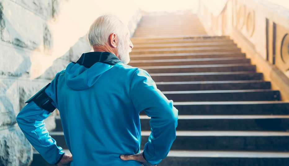 man in workout jacket prepares to climb steep staircase