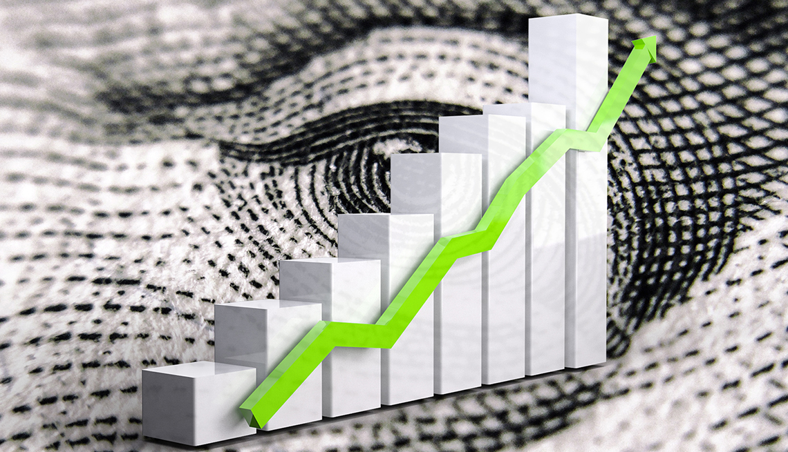 A rising green arrow superimposed on a bar chart and extreme closeup of U.S. currency