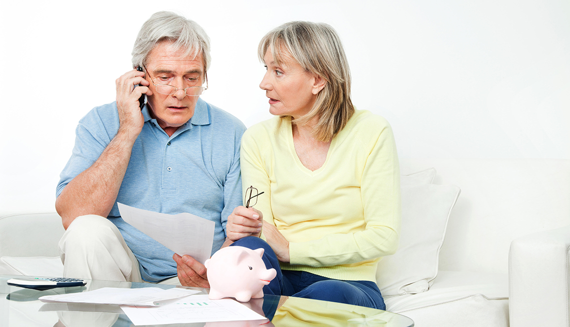 An older couple sits on the couch