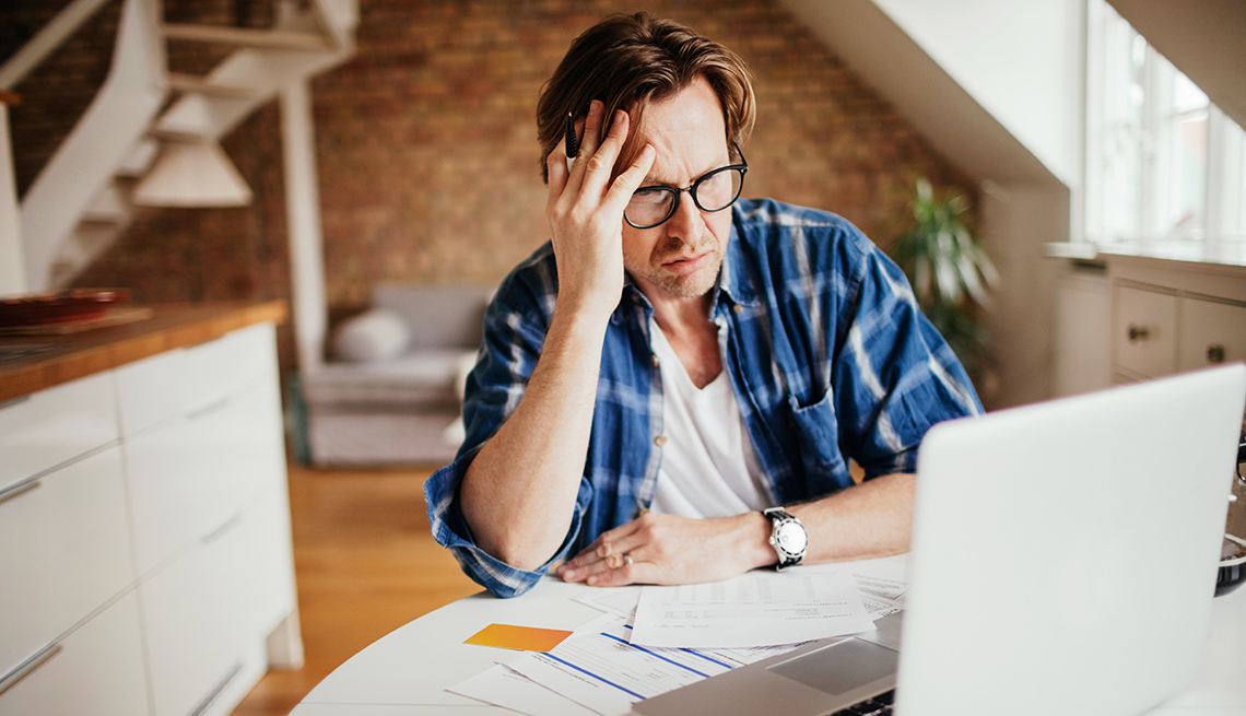 Man looks stressed in front of laptop
