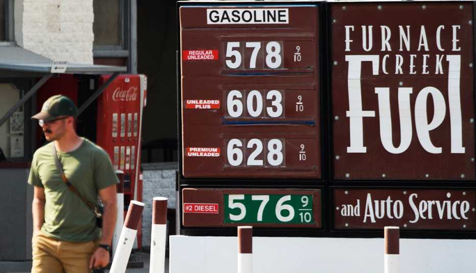A customer walks past a gas station sign where fuel prices above $5 and $6 per gallon. A customer walks by a gas station sign that says Funace Creek Fuel, where fuel prices above $5 and $6 per gallon.