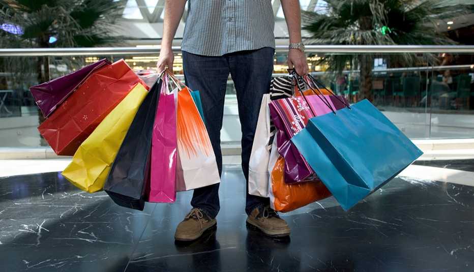 man holding an large amount of shopping bags