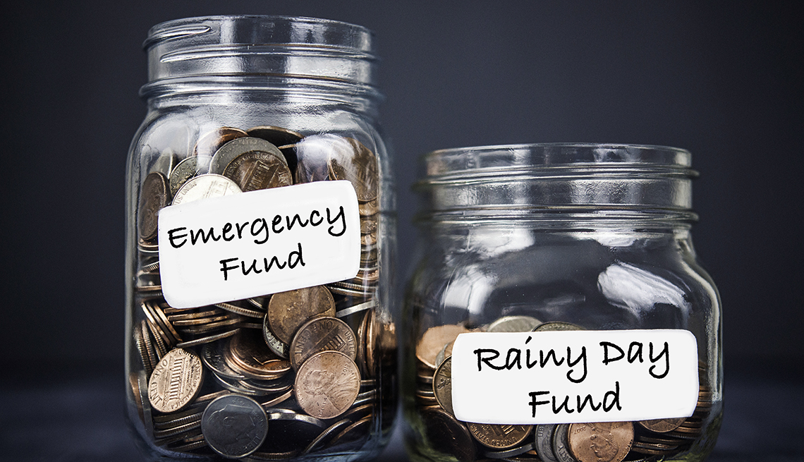 two jars filled with coins. One jar is larger and is labeled emergency fund, the other jar is smaller and contains fewer coins. it is labeled rainy day fund