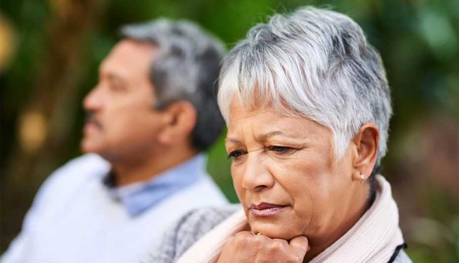 woman looking upset with her husband in the background