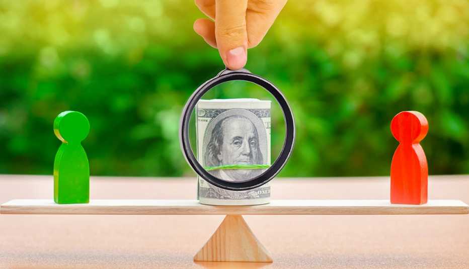 Wooden figures of people on scales and dollars banknotes between them. The concept of separation of money. Property division. Divorce and legal services. 