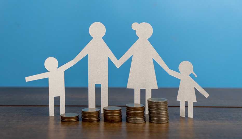 a paper cut out family with coins on a table with a blue background