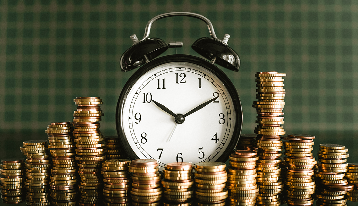 Time of a clock with stacked coins all around it 
