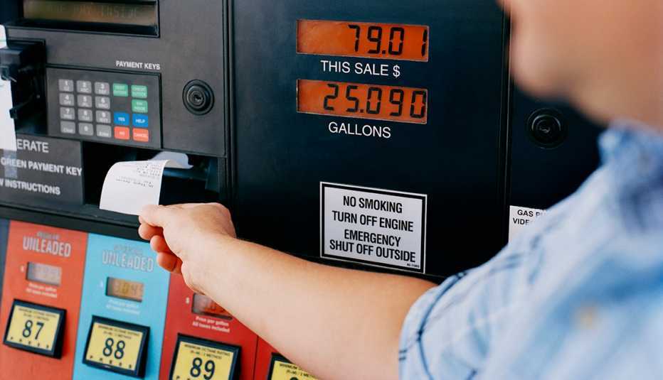 man pulling receipt from a gas pump