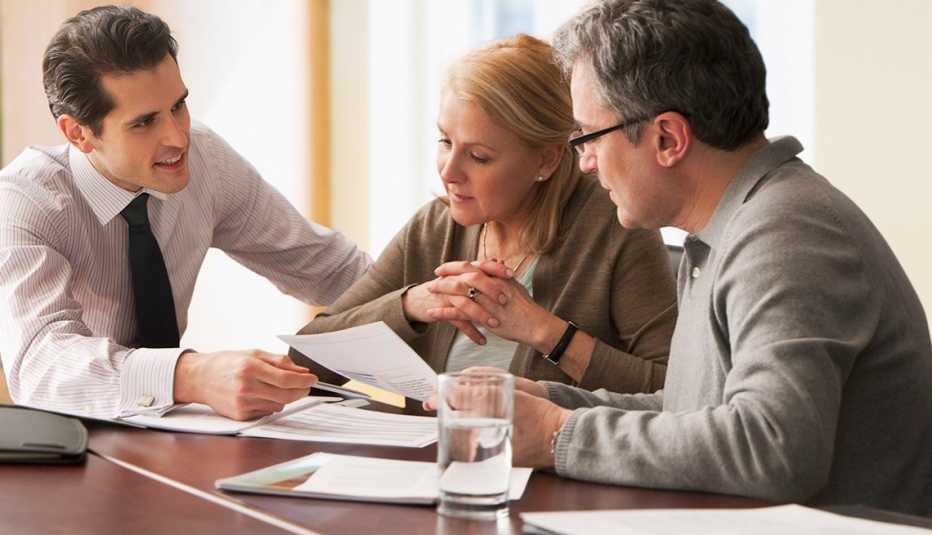 Counselor going over papers with older couple Counselor going over papers with older couple