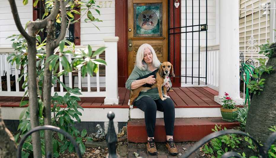 Susan Kelly at home with her rescue beagle, Tyson. susan kelly sits on her porch with her rescue beagle tyson on her lap