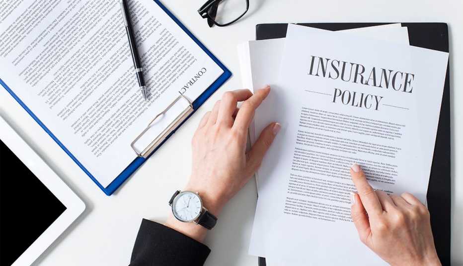 Business woman showing insurance document over white desk at office