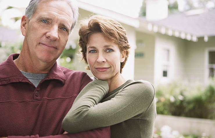 Couple standing in front of house. Why retirees can't get a mortgage. Couple standing in front of house. Why retirees can't get a mortgage.