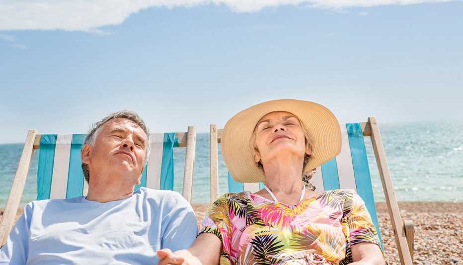 Couple in beach chairs, holding hands, smiling 