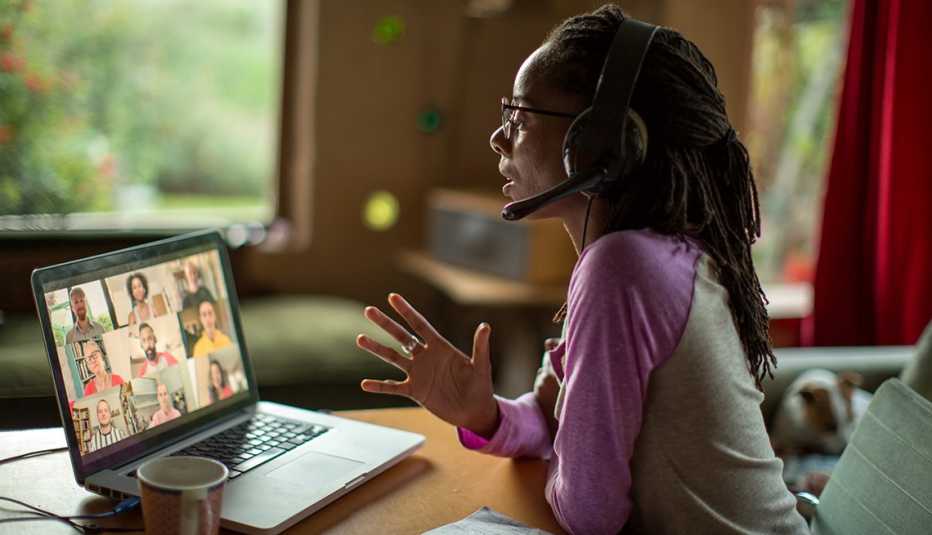 A women is working from home while talking to people on a video conference