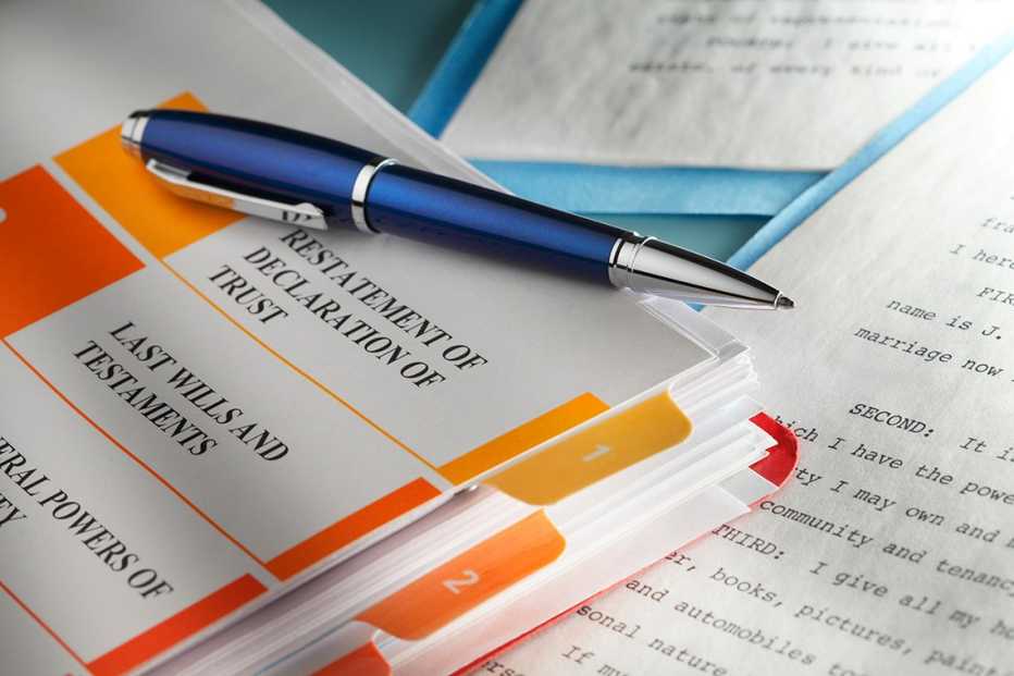 A blue ballpoint pen rests on top of trust documents. 